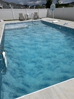 New 16x32 rectangular vinyl liner pool installation in Old Bridge NJ featuring an under-liner sundeck, custom shallow-end steps, and poured concrete deck