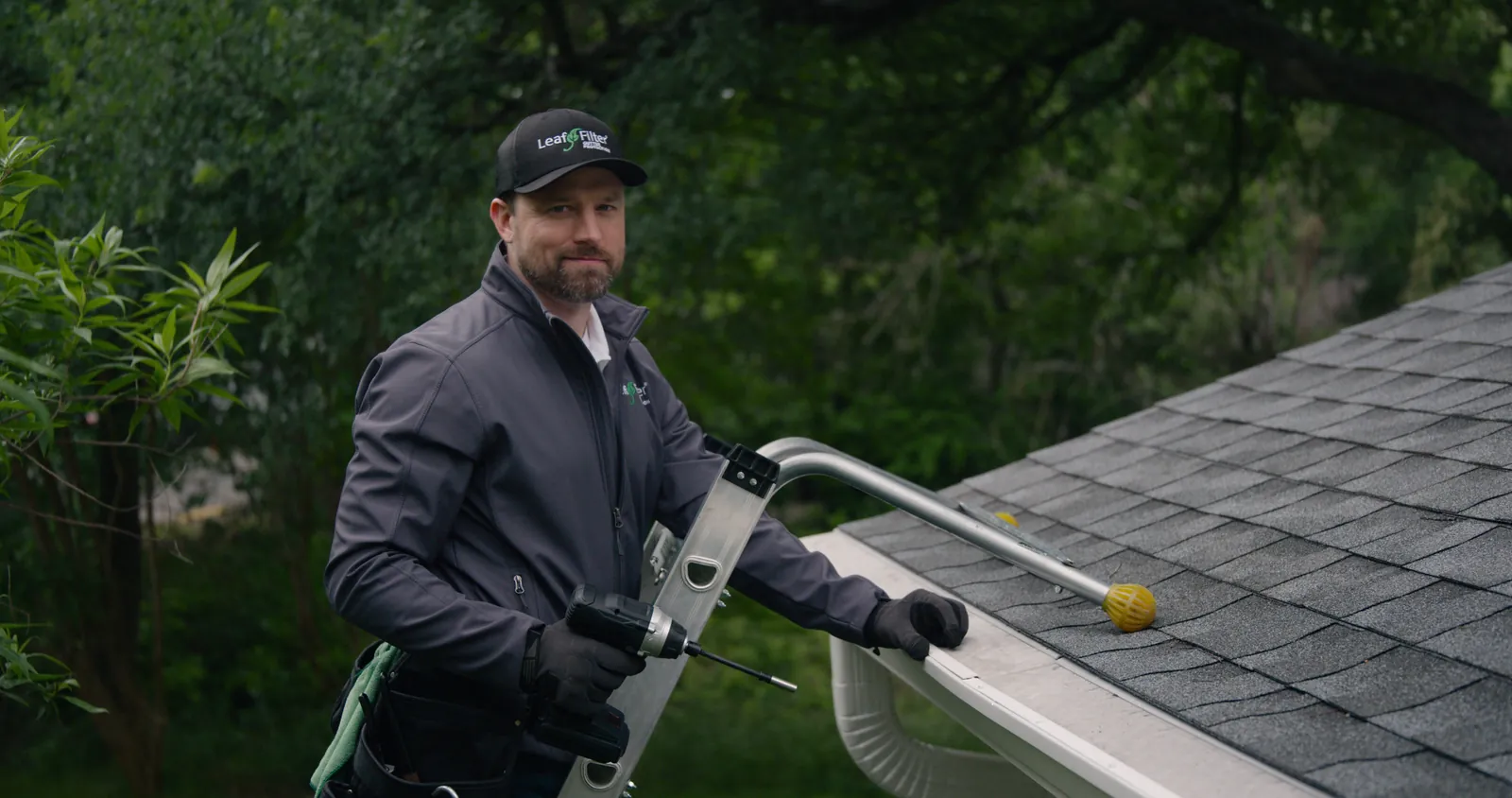 LeafFilter installer cleaning a gutter on a roof in Quad Cities, Iowa