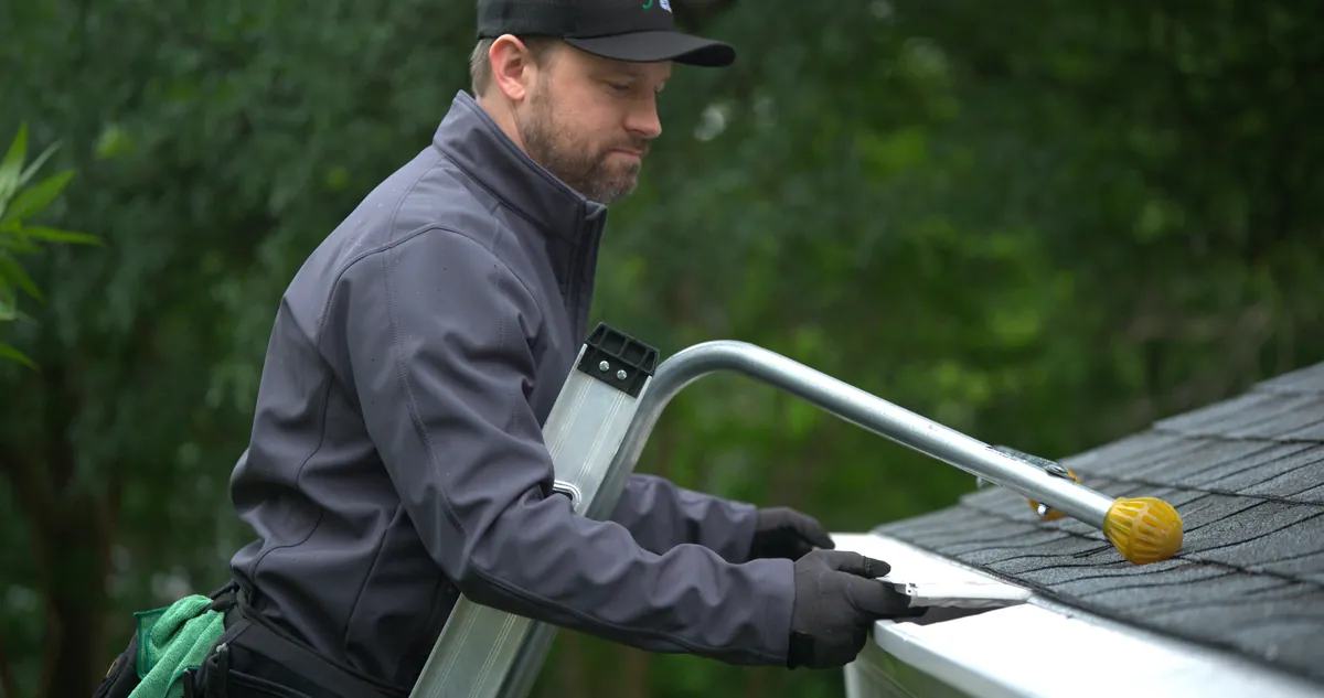 Installer fitting LeafFilter stainless steel micromesh onto a gutter
