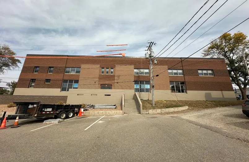 Human Services Building in Albert Lea during exterior facade restoration including tuckpointing and waterproof coating application