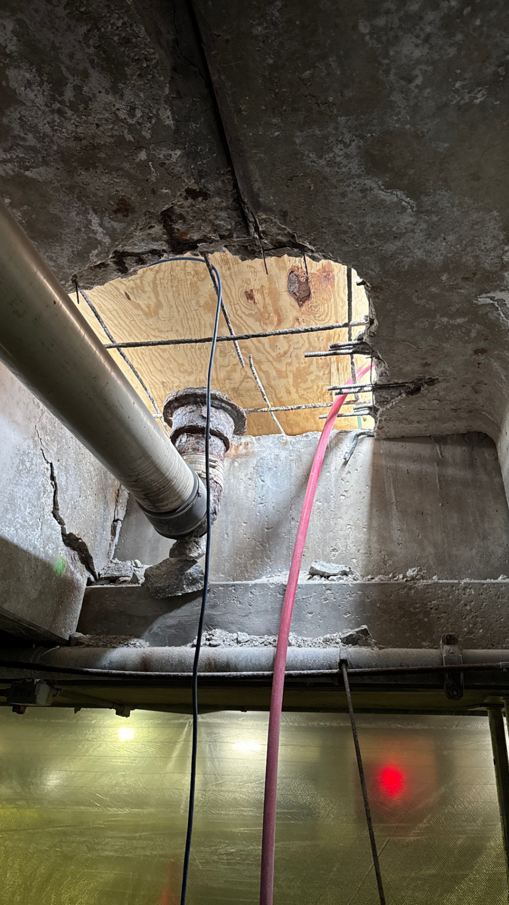 Corroded drain pipe and deteriorated concrete exposed during the demolition phase of structural drain replacement in a Milwaukee underground parking ramp