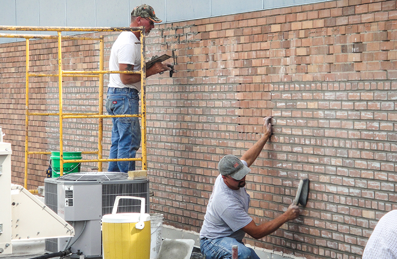 Structural brick repair in progress showing helical tie installation at St. Cloud College