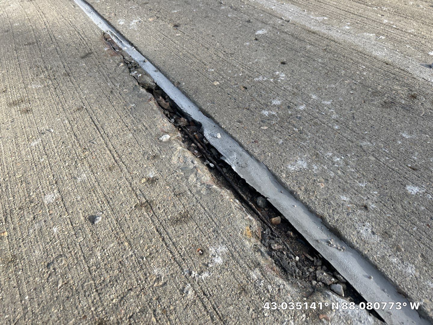 Deteriorated expansion joint in a parking garage deck with failed sealant and sub-surface erosion from moisture infiltration