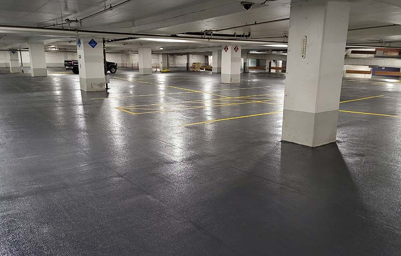 St. Paul municipal parking structure during comprehensive traffic coating rehabilitation, showing polyurethane waterproofing membrane installation across multiple levels