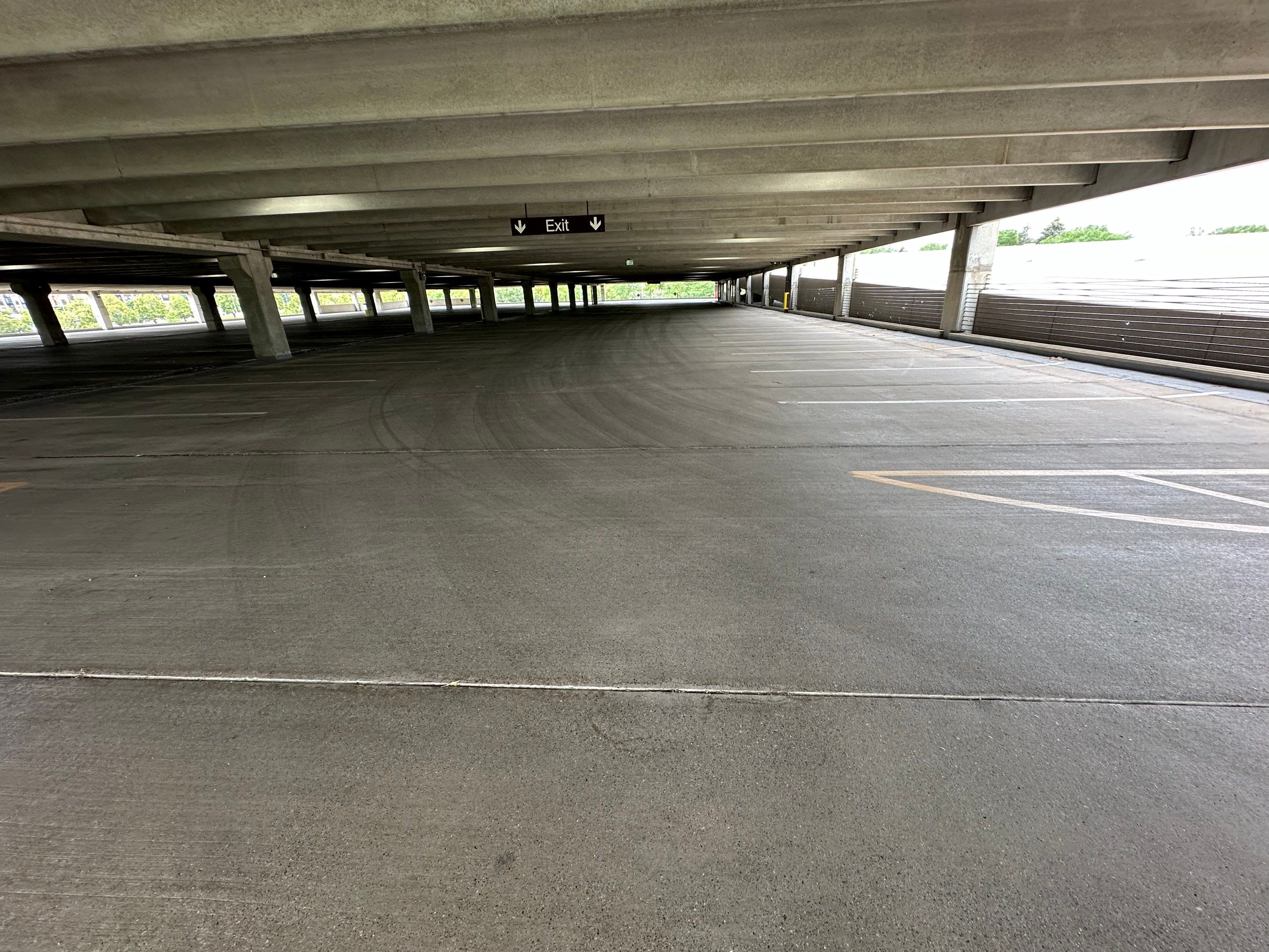 Concrete underside of a bridge or overpass showing rust stains, efflorescence, and water damage streaking downward.