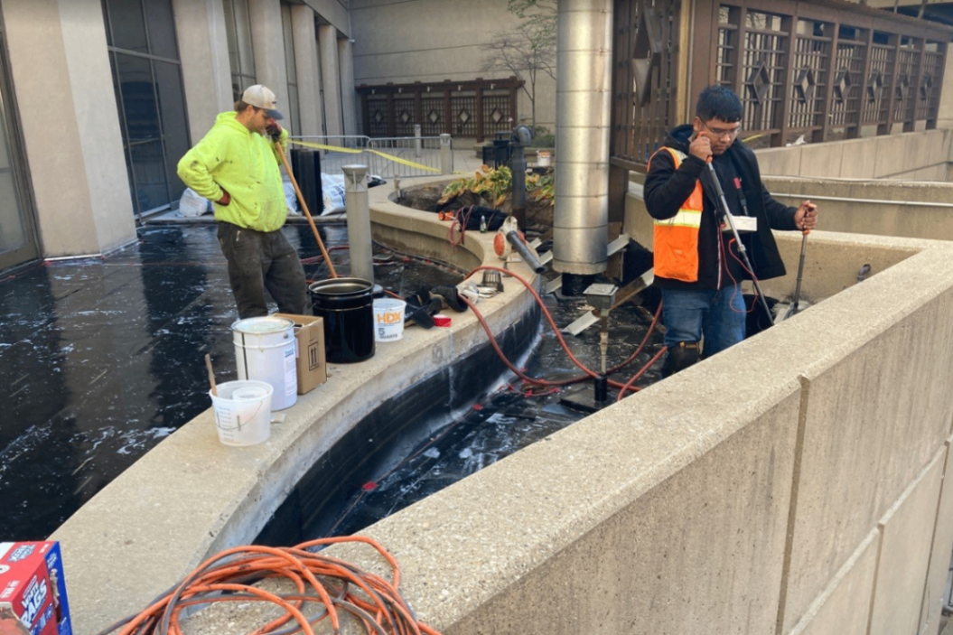 Commercial waterproofing application on Milwaukee plaza deck showing professional hot-applied membrane installation