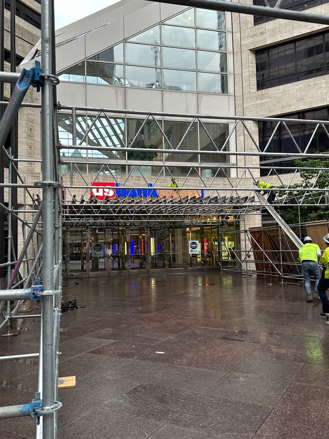 RSI construction setup near the entrance of the US Bank building, with safety barriers and equipment in place