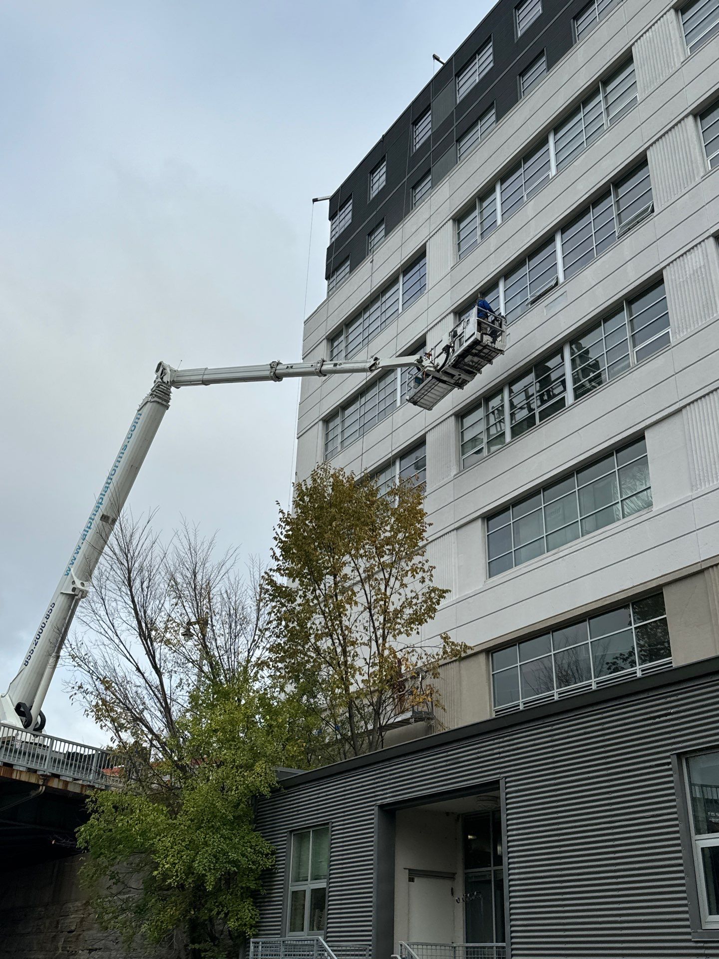 RSI crew media-blasting failed coating from the cast-in-place concrete elevations at UW Milwaukee Kenilworth