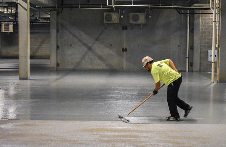 RSI technician removing traffic coating from parking deck surface at Avidor Apartments in Edina, Minnesota