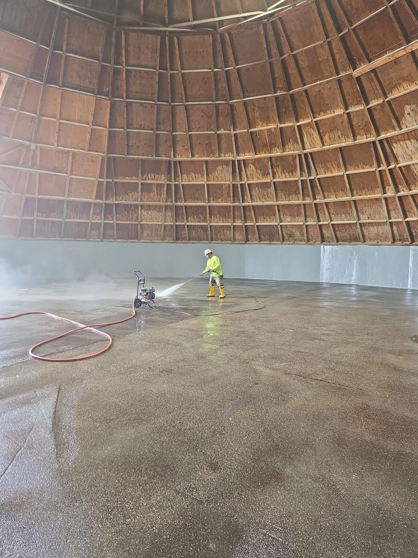 RSI crew member pressure-washing the interior concrete of a municipal salt shed before an industrial protective coating is applied