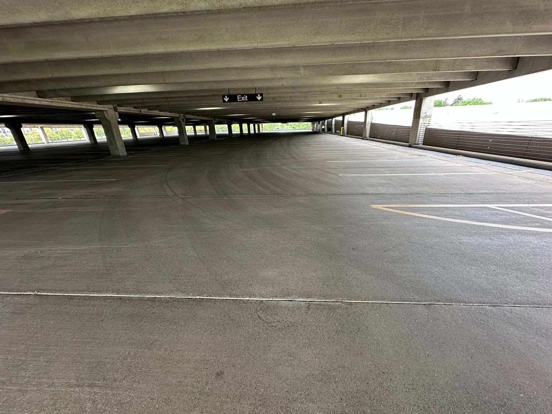 Commercial parking deck drive lane with vehicle barrier system along the perimeter